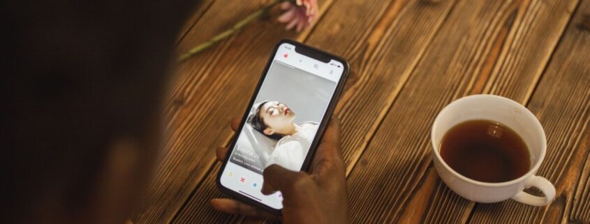 Person nutzt Dating-App am Smartphone