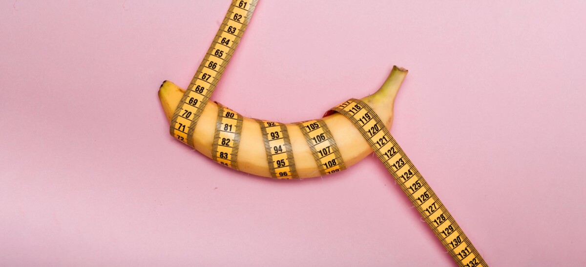 Banane mit pinkem Maßband umwickelt, pinker Hintergrund
