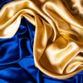 Nahaufnahme blau-goldener Seidenstoff, edel drapiert
