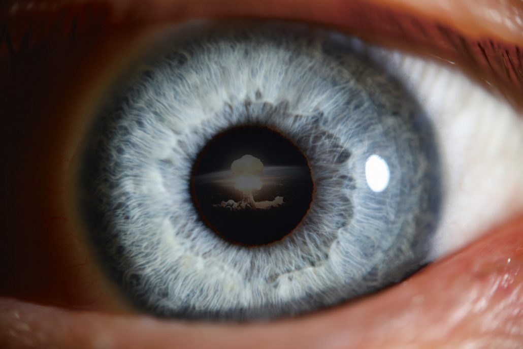 Das Bild von einem Auge, in dem sich ein Atompilz spiegelt, vor dem der Betrachter offenbar Panik hat. 
