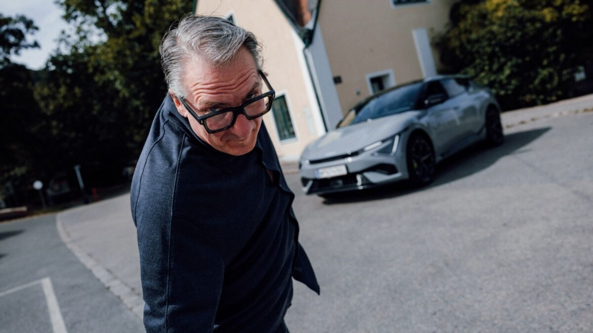Robert Palfrader bei der Übergabe des Kia EV6, daneben das vollelektrische Fahrzeug