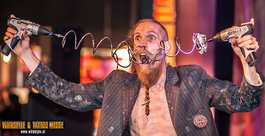 Sideshow-Künstler Andrew S. mit zwei Akkuschraubern und Spiralen im Gesicht
