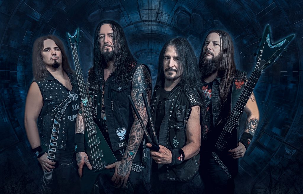 Die Thrash-Metal-Band Destruction in Lederwesten mit Gitarren vor blauer Kulisse