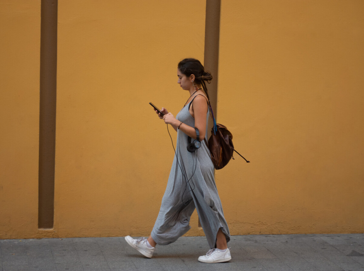 Junge Frau hört Musik über eine Streaming-App am Smartphone