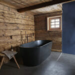 Freistehende Badewanne mit Naturofloor-Boden in Steinbraun im Baschli Haus