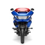 Zu sehen ist die Frontansicht eines blauen Harley-Davidson-Touring-Motorrads mit roter Verkleidungsscheibe vor weißem Studiohintergrund.