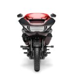 Zu sehen ist ein schwarz-rotes Motorrad in der Frontalansicht vor weißem Hintergrund.