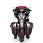 Ein dunkelrotes Motorrad mit Seitenkoffern in Heckansicht vor neutralem weißem Hintergrund.