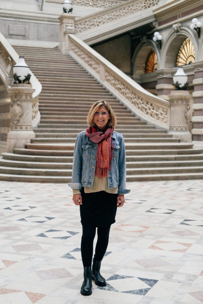 Beate Maly lächelnd auf einer Treppe, Wiener Autorin historischer Kriminalromane