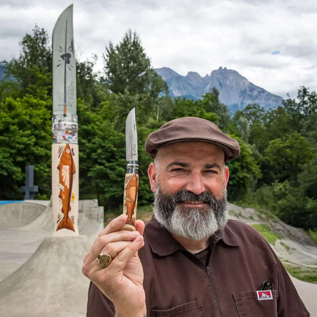 Künstler Jeremy Fish hält das Opinel N°08 The Swordfisherman vor dem Riesenmesser im Skatepark