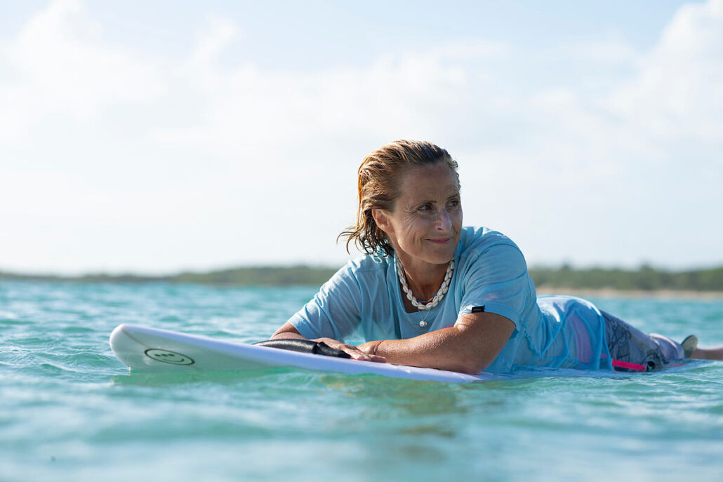 Sam Bloom, vierfache Weltmeisterin im Parasurfen, auf dem Surfbrett im Meer