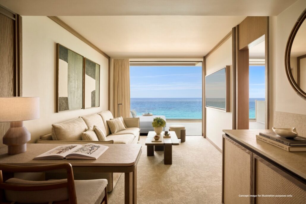 Helles Hotelzimmer mit Sofa, Tisch und offener Fensterfront mit Blick auf das Meer