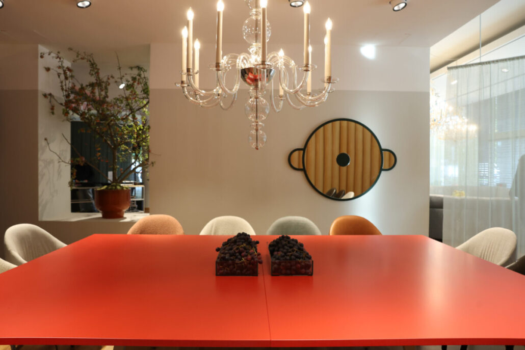Roter Esstisch unter Kristalllüster im Wittmann Showroom in Wien