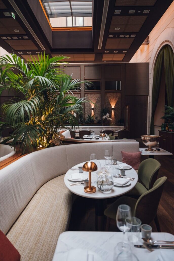 Eleganter Gastraum der Brasserie Sophie mit Marmortischen und Pflanzen