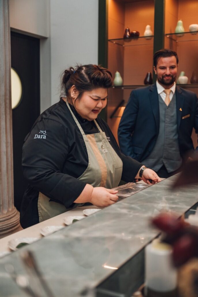 Chef Hongz im Gespräch an der Küchenzeile neben einem Mann im Anzug