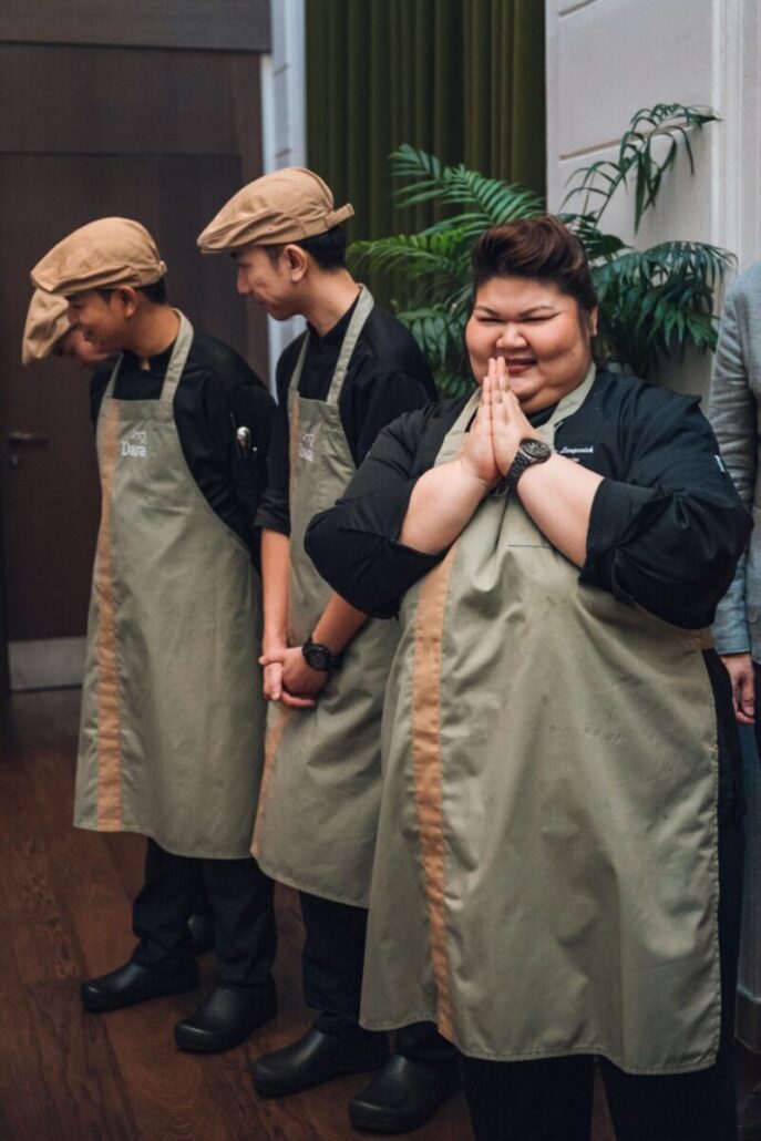 Chef Hongz lacht mit zwei Teammitgliedern in DARA-Schürzen